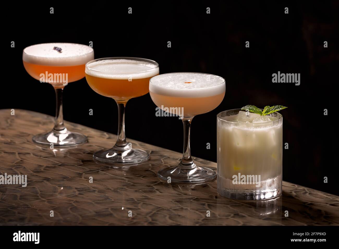 Close up on a cocktail selection made of four drinks served straight up and one on the rocks all with egg white, fruity and strong Stock Photo