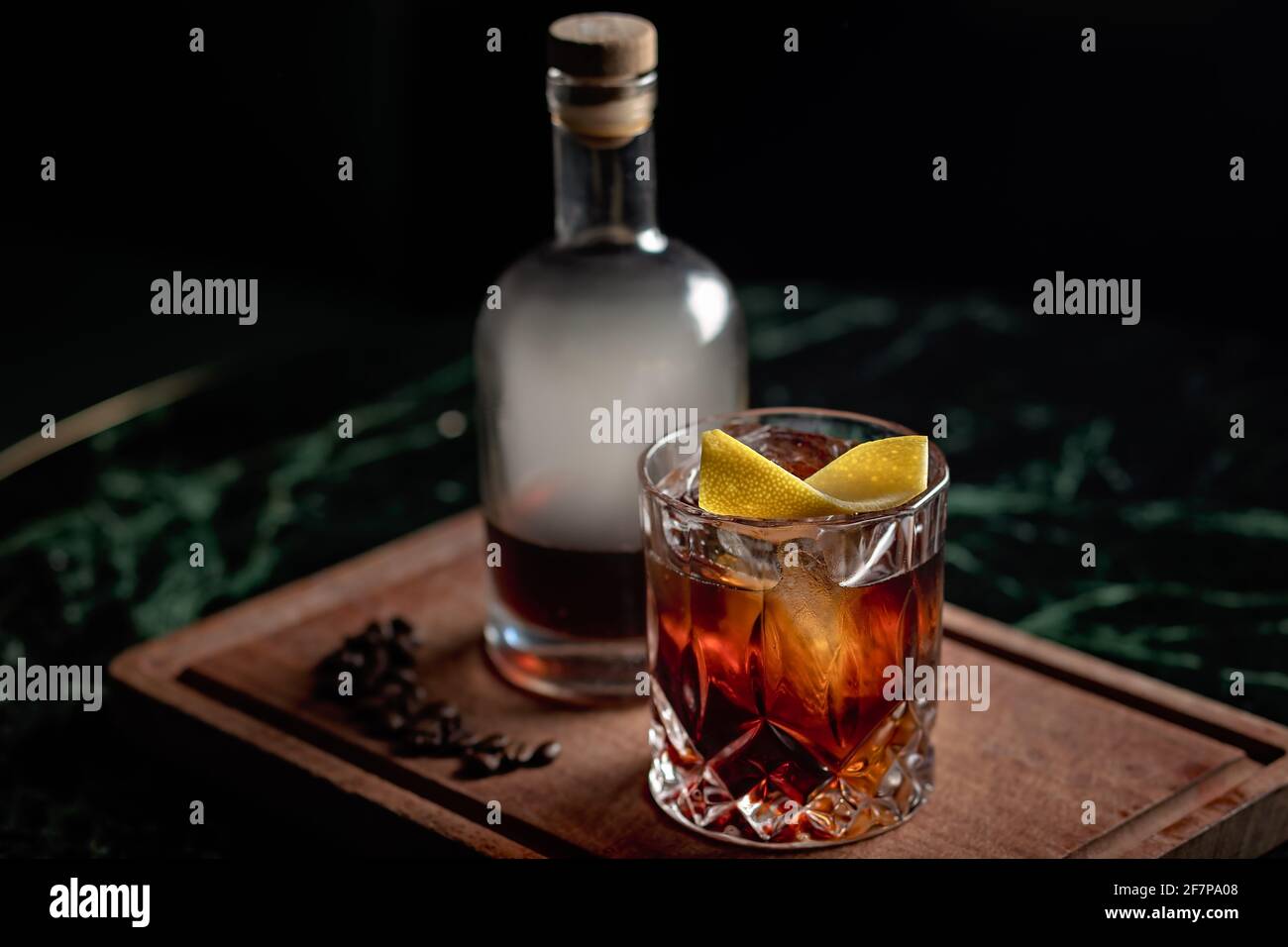 A beautiful Old Fashioned cocktail served with coffee-infused aged rum over ice on a rock glass. The cocktail is presented in a bottle with smoke Stock Photo