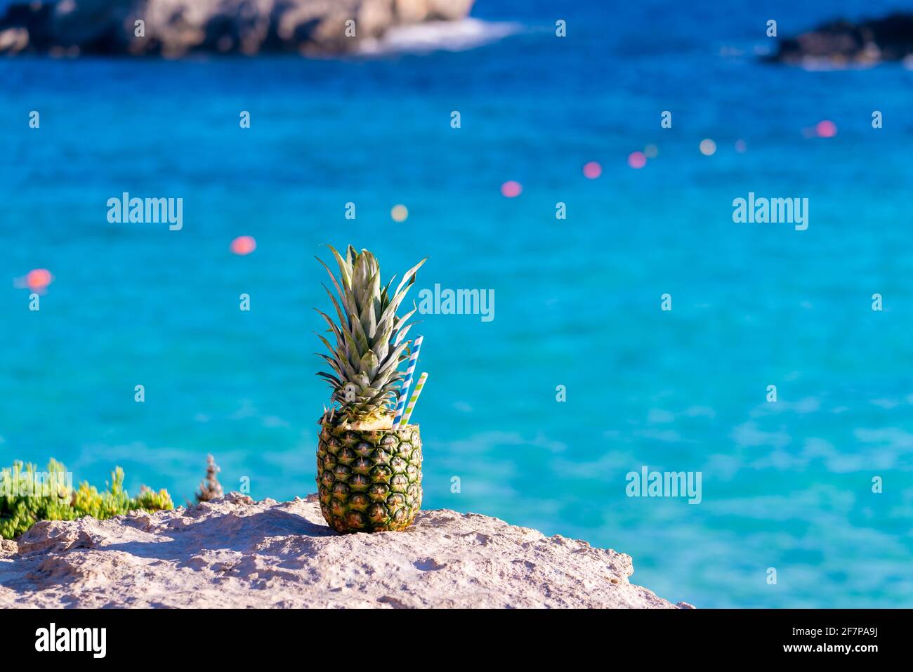 Cocktail in pineapple on the background of the blue sea Stock Photo