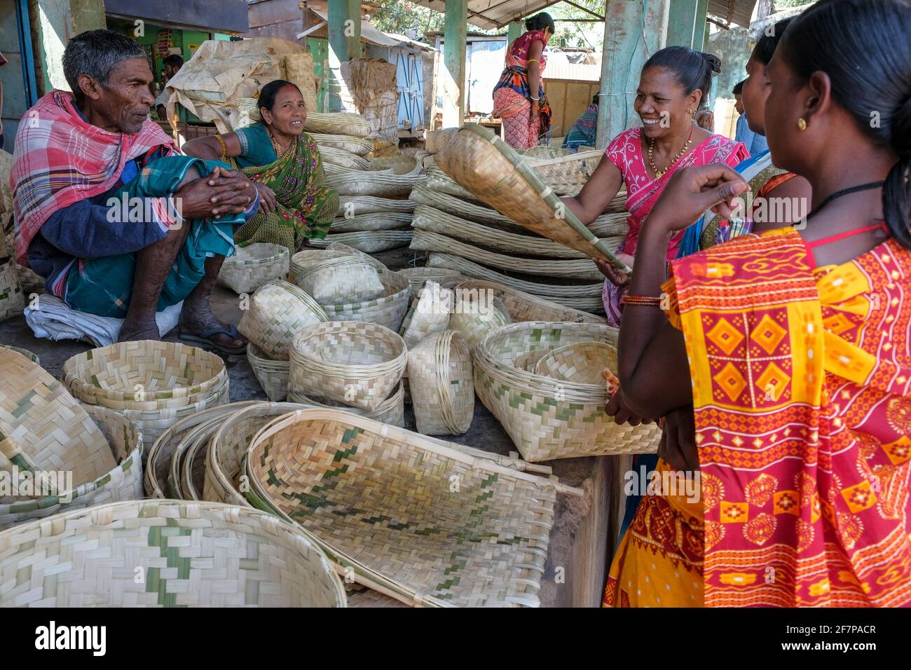 Koraput, India - February 2021: Adivasi women from the Kondh tribe buying cane baskets in the Koraput market on February 21, 2021 in Odisha, India. Stock Photo