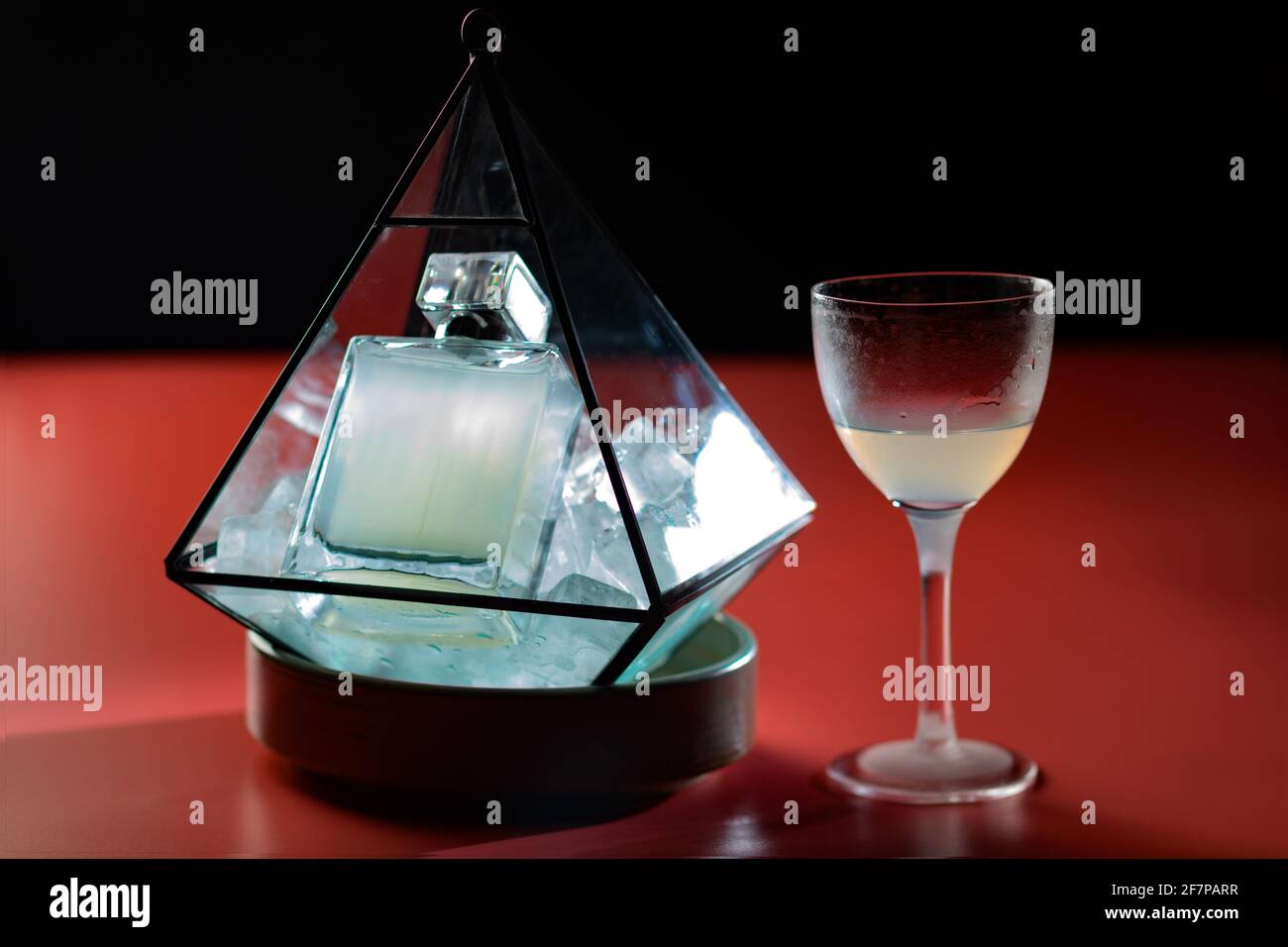 Really nicely presented cocktail, served in a parfum bottle on ice inside a transparent diamond shape box with a Nick and Nora glass to drink it Stock Photo