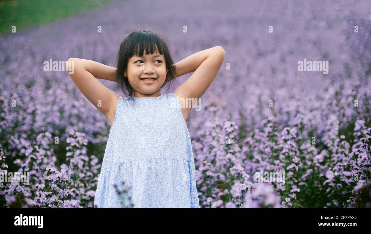 Asian little  child girl smiling in flower fields Stock Photo