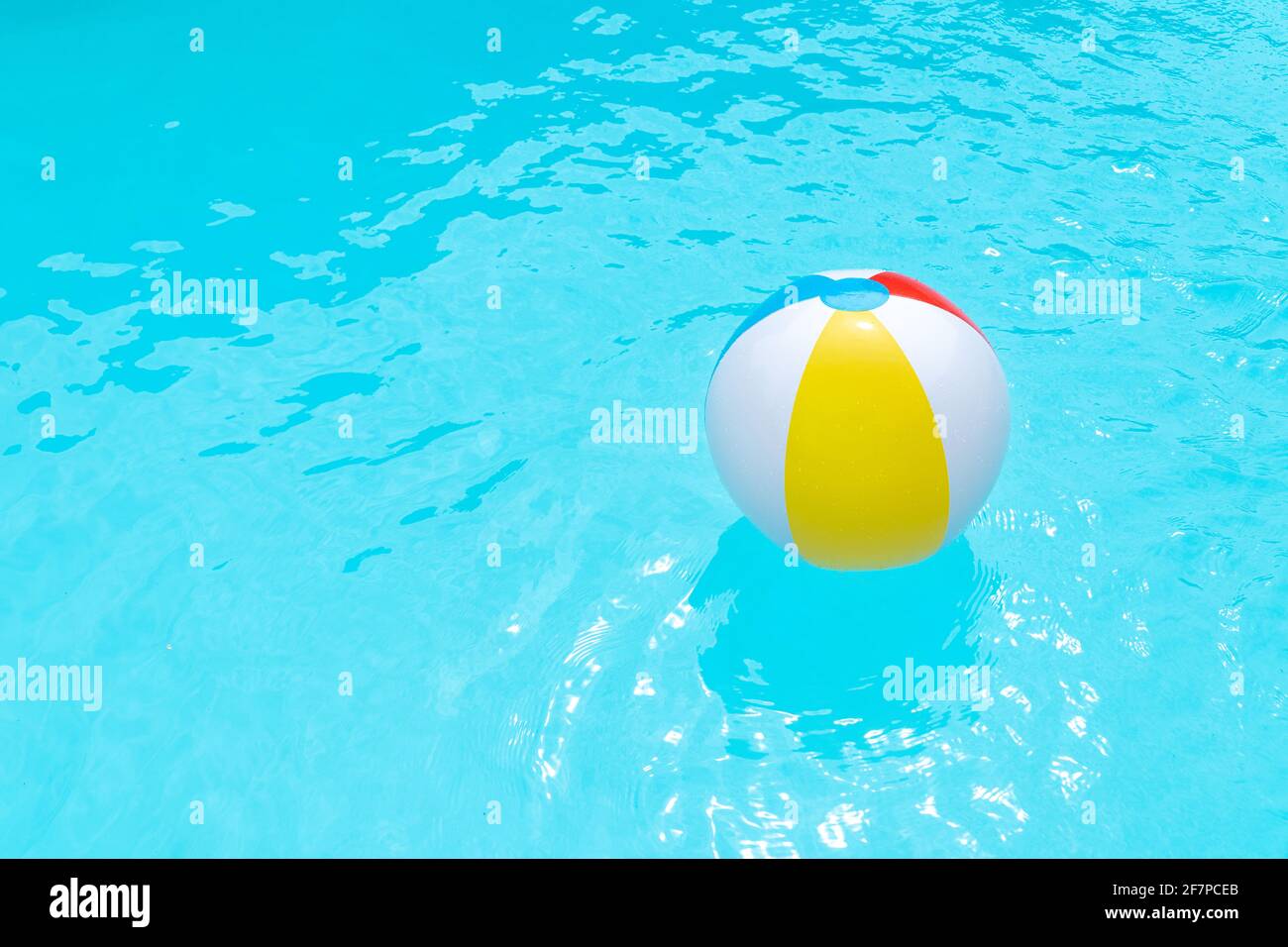 Beach Ball Floating on water surface of a swimming pool. Summer