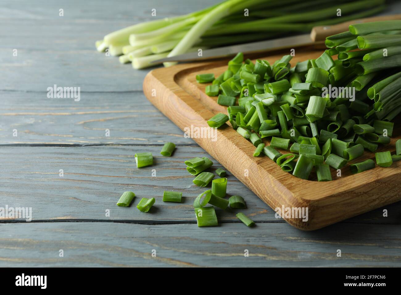 Fresh green onion on cutting board, on gray wooden table Stock Photo ...