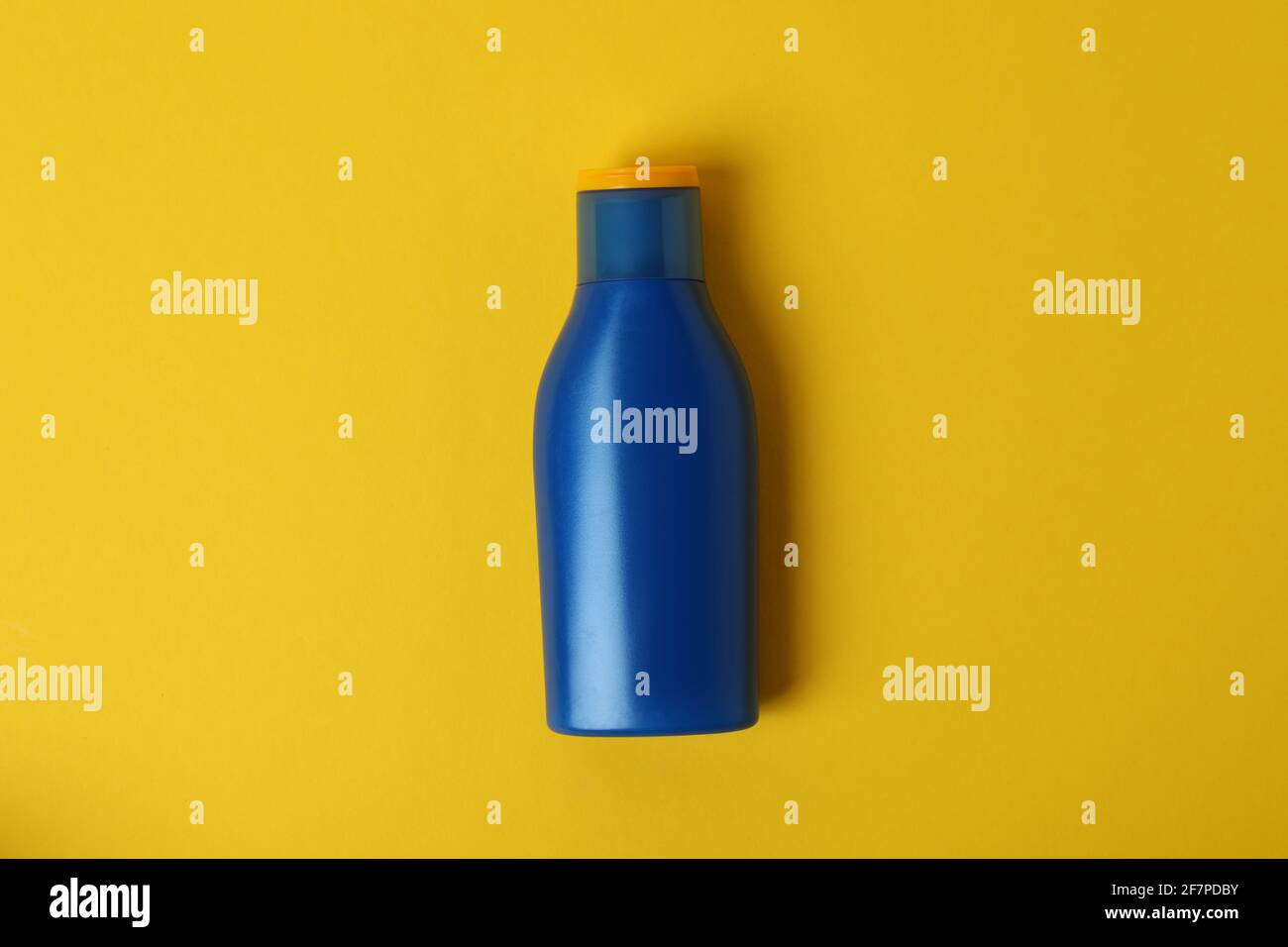 Blue bottle of sunscreen on yellow background Stock Photo - Alamy