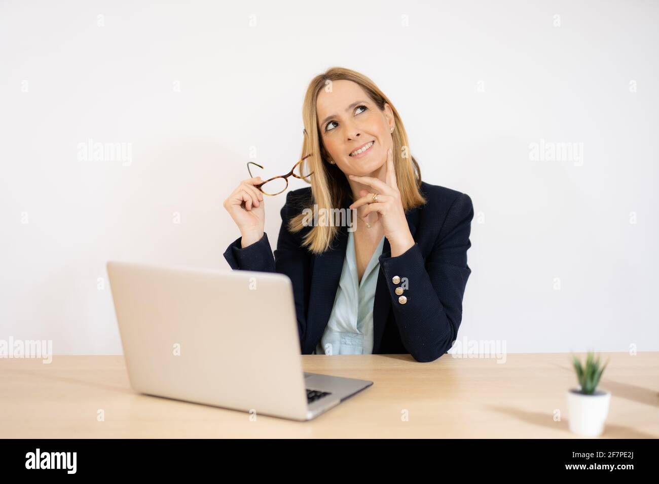Concentrated young beautiful business woman working on laptop in office ...