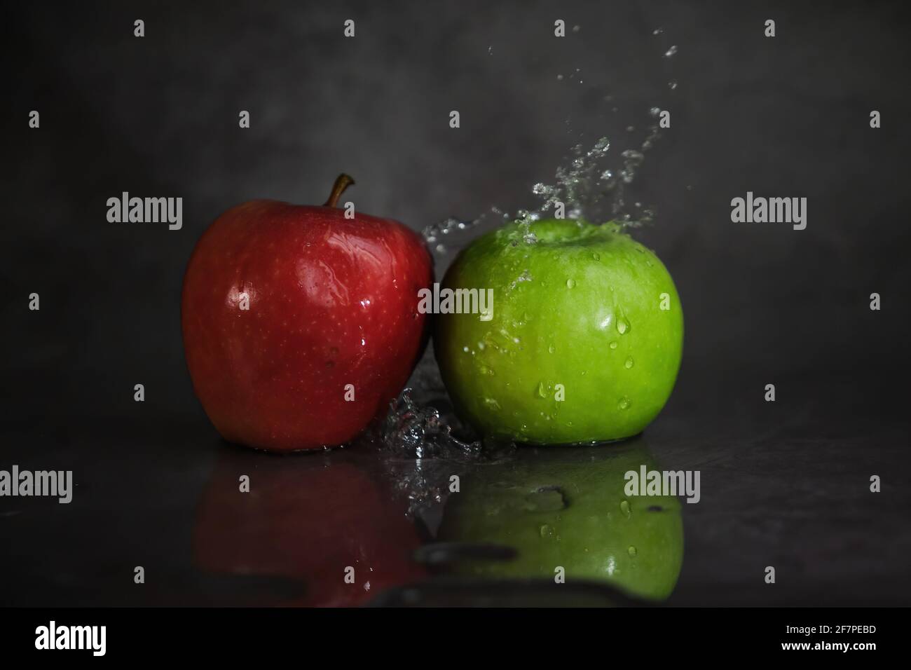 red and green apples in splashes of water Stock Photo