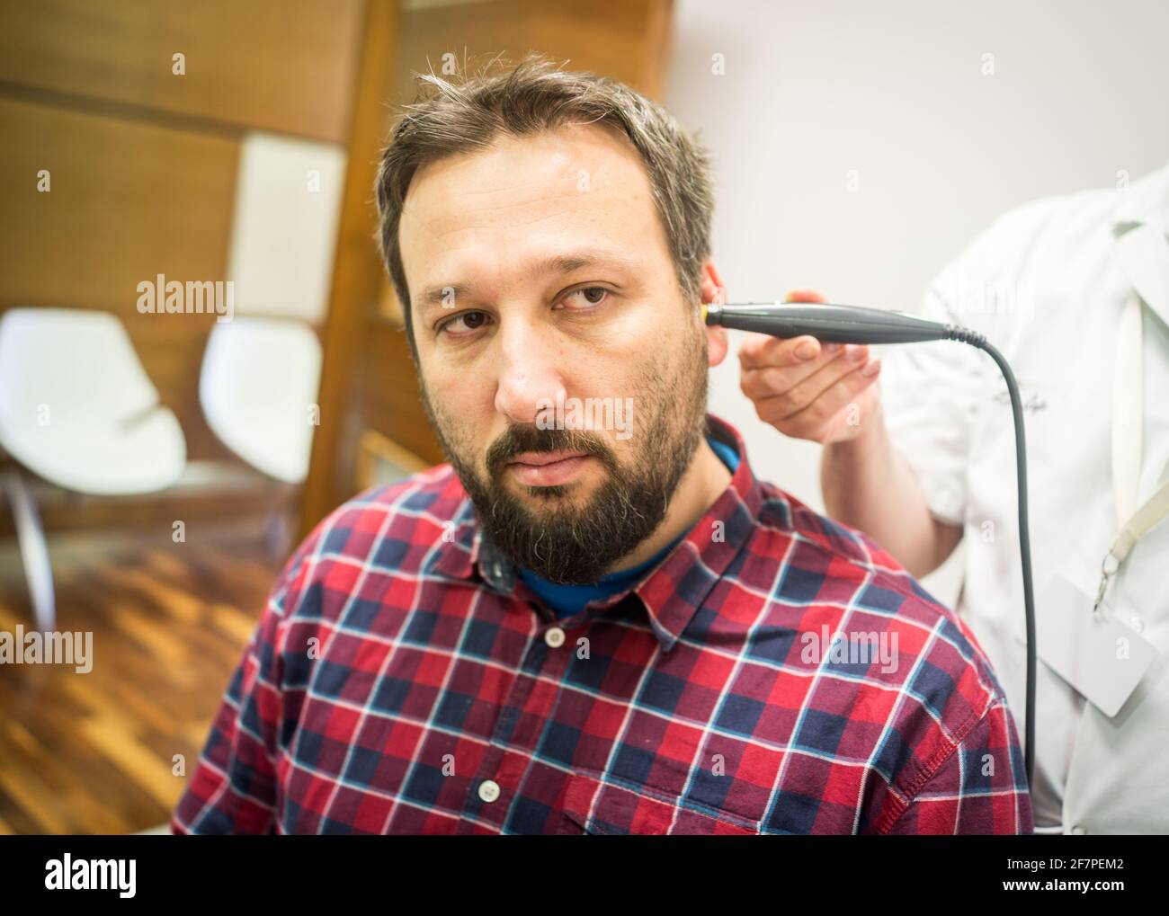 Doctor in hospital checking patient the ear Stock Photo