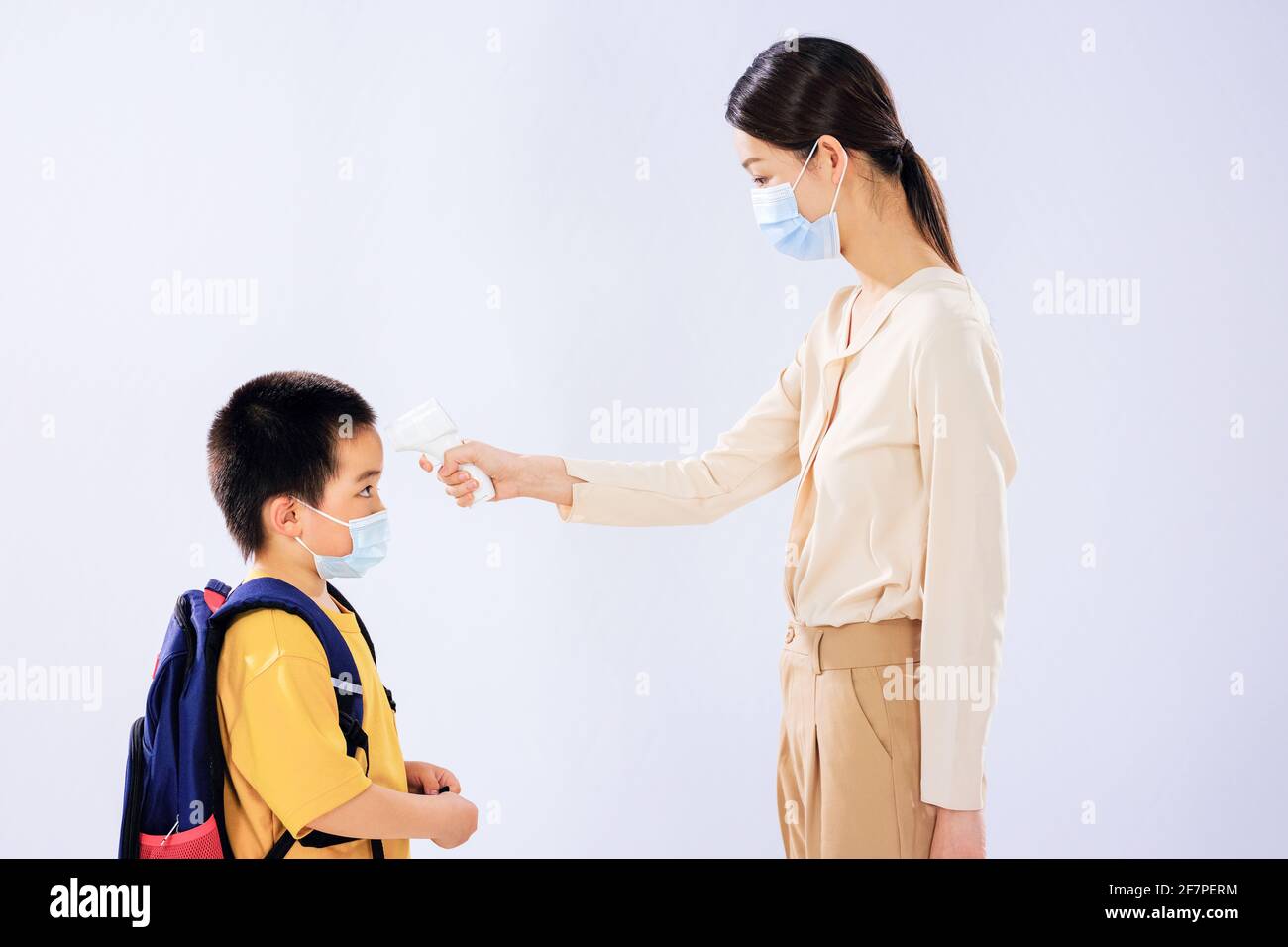 The little boy took his temperature before school by his mom Stock Photo