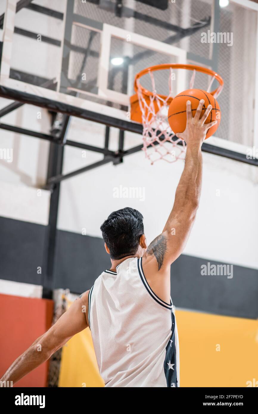 Sportman throwing a ball into the basket Stock Photo - Alamy