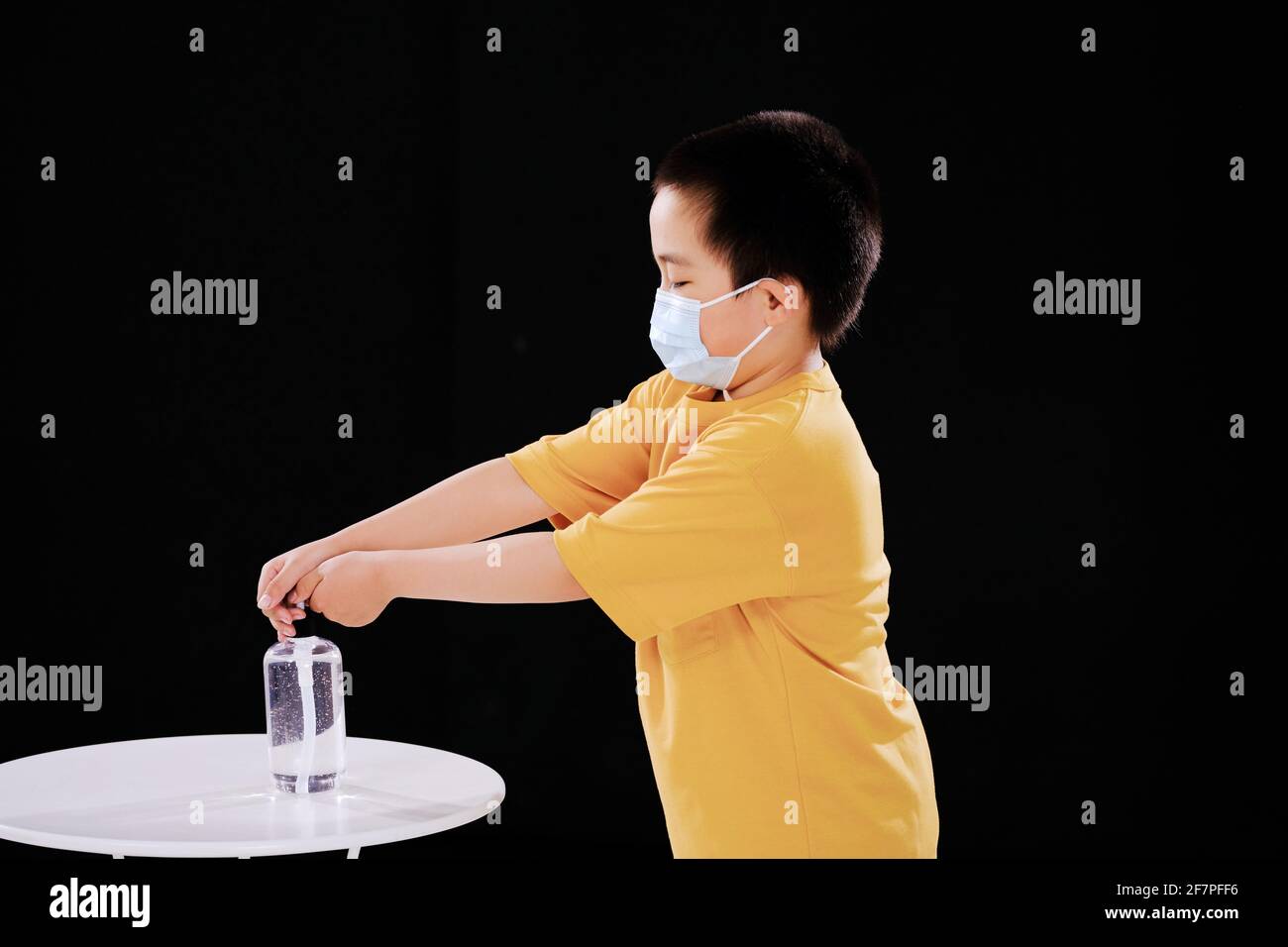 a Little boy with masks use hand sanitizer Stock Photo