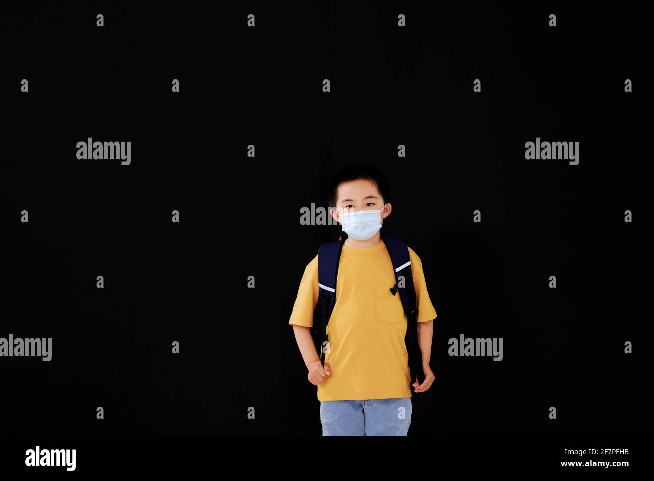 The little boy with mask goes to school standing Stock Photo