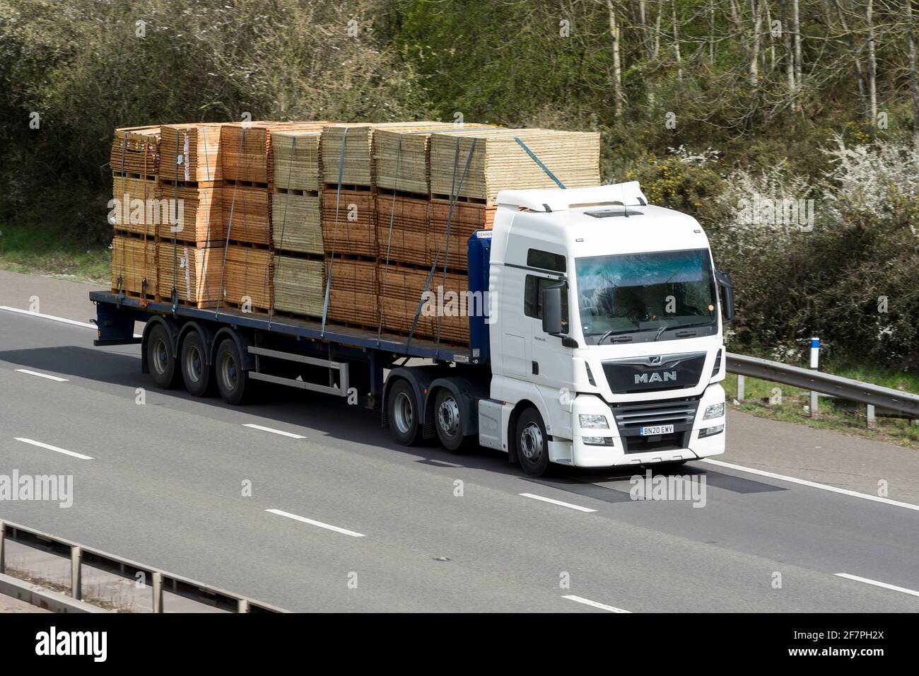 A MAN lorry carrying fencing panels on the M40 motorway, Warwickshire, UK Stock Photo