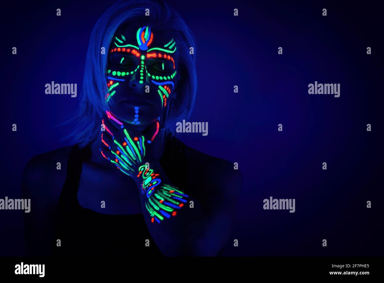 Portrait of woman with neon makeup, which made of fluorescent paint in