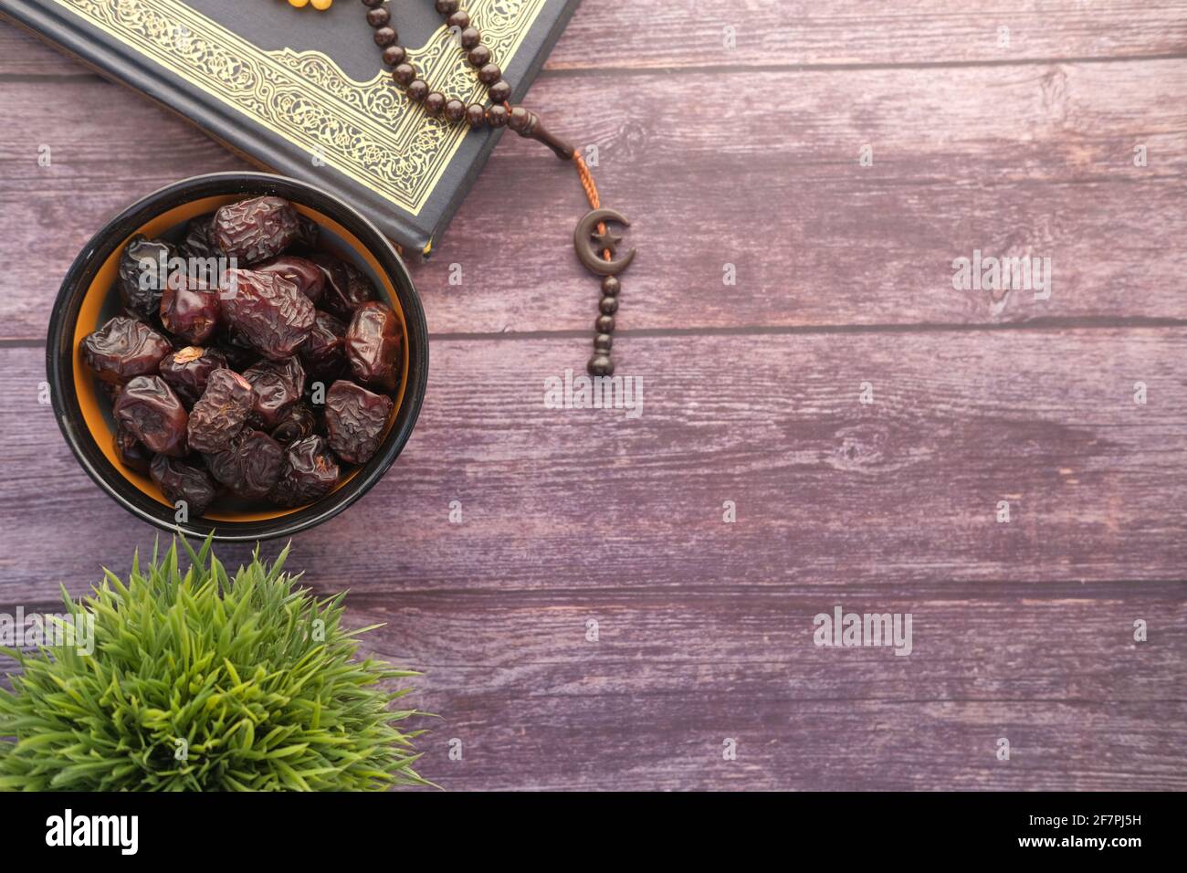 Holy book Quran, rosary and date fruit on table with copy space  Stock Photo