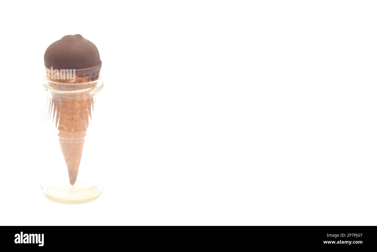 Chocolate ice-cream cone in small glass bottle on white background, copyspace Stock Photo