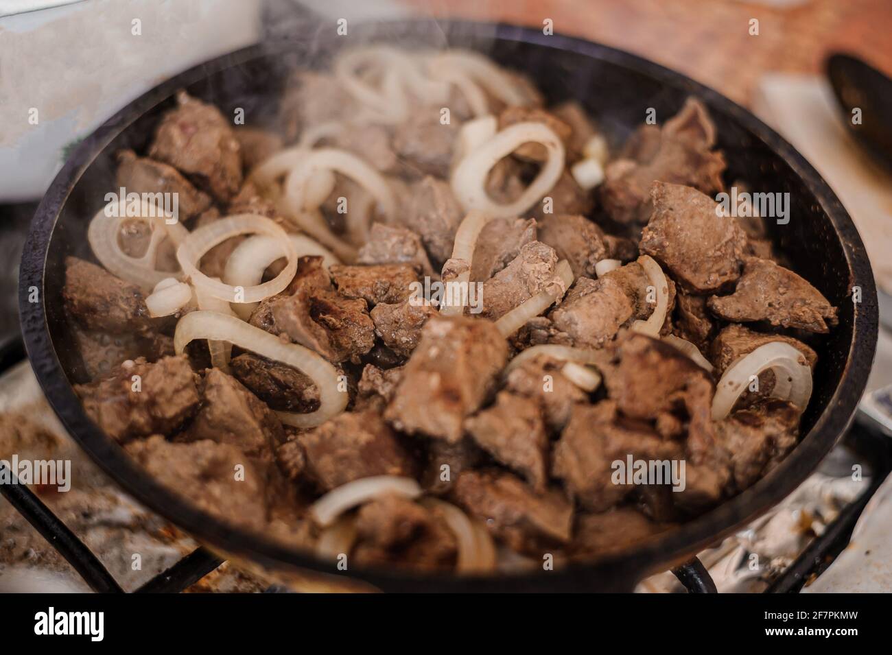 Fried veal liver with onions in a pan. Braised cow and pork liver Stock
