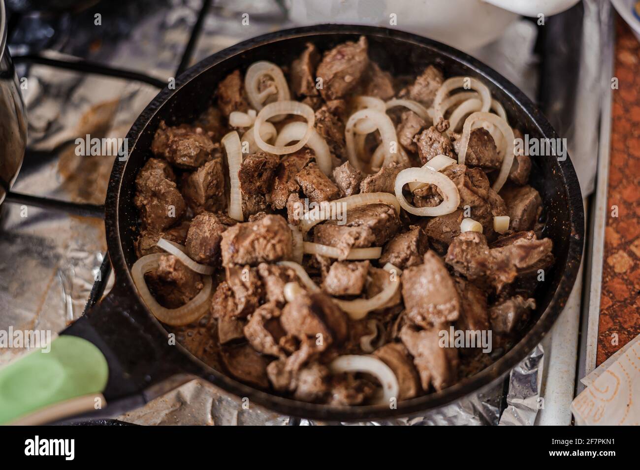 Fried veal liver with onions in a pan. Braised cow and pork liver Stock