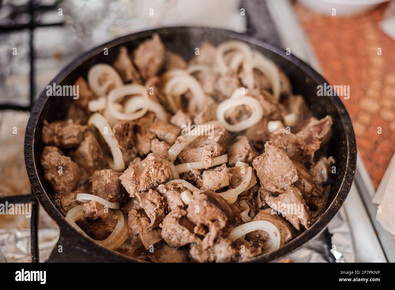 Fried veal liver with onions in a pan. Braised cow and pork liver Stock