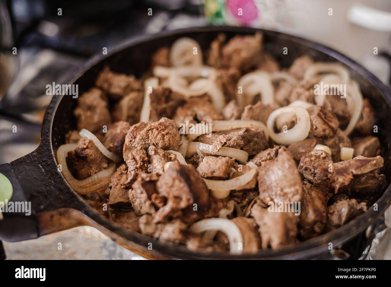 Fried veal liver with onions in a pan. Braised cow and pork liver Stock