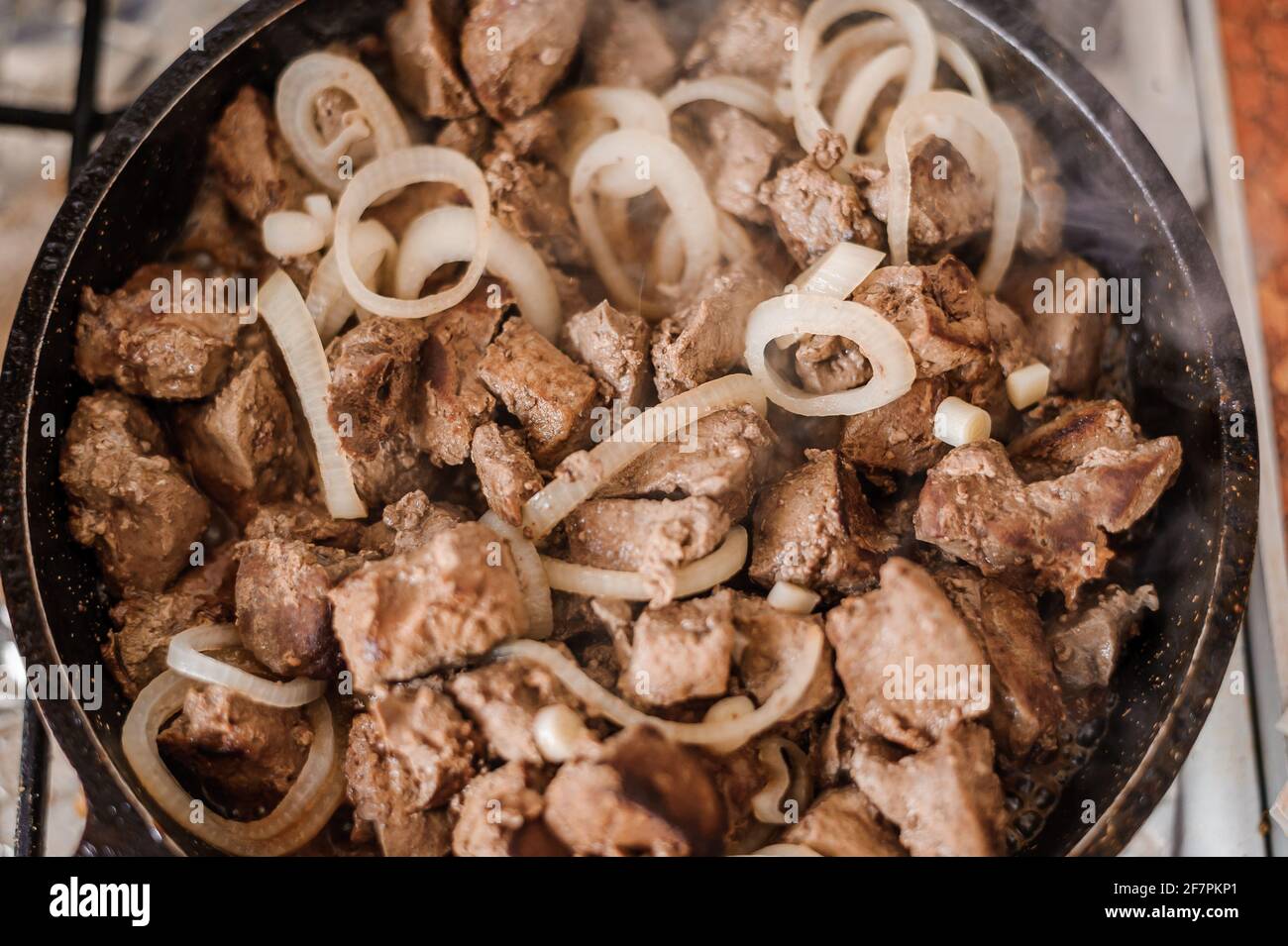 Fried veal liver with onions in a pan. Braised cow and pork liver Stock