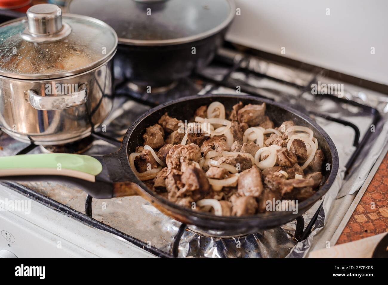 Fried veal liver with onions in a pan. Braised cow and pork liver Stock