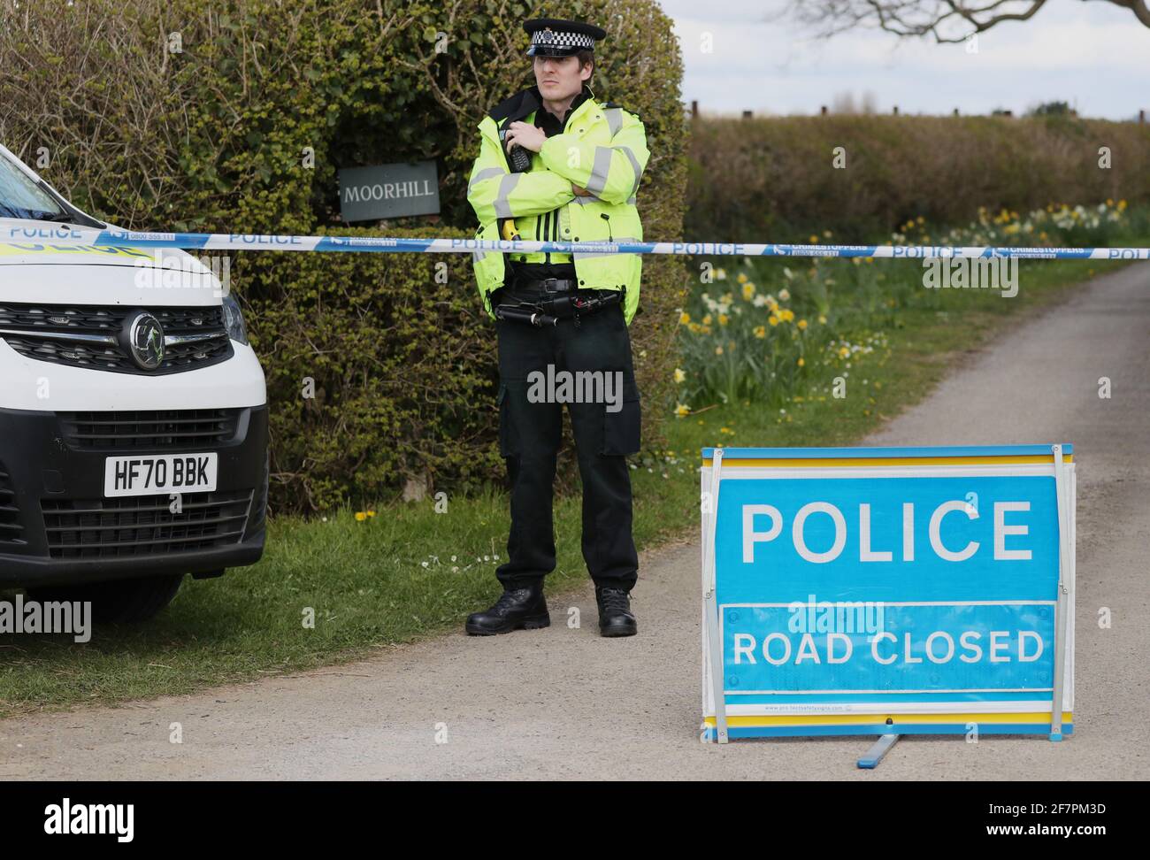 A police officer mans a cordon at the junction of Moor Lane and Langham Lane in Gillingham, Dorset, following the death of Sir Richard Sutton, who owned a string of top hotels in London, who died during an incident at a property near Gillingham, Dorset. A 34-year-old man arrested on suspicion of murdering the millionaire hotelier remains in hospital, police said. Picture date: Friday April 9, 2021. Stock Photo