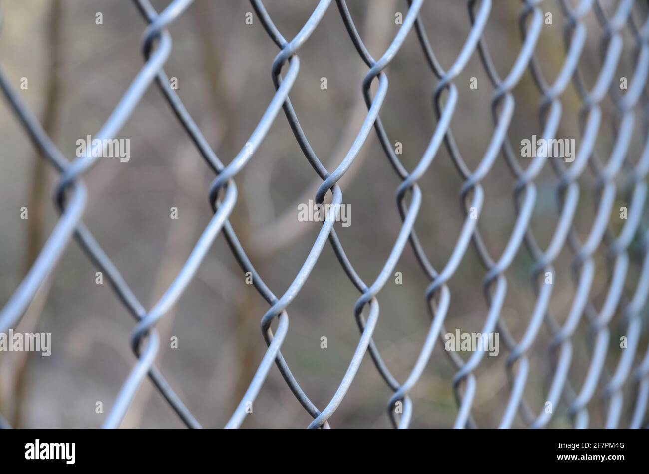 Close-up of metal chain-link fence, diamond pattern, with shallow depth of field or selective focus, abstract background or backdrop Stock Photo