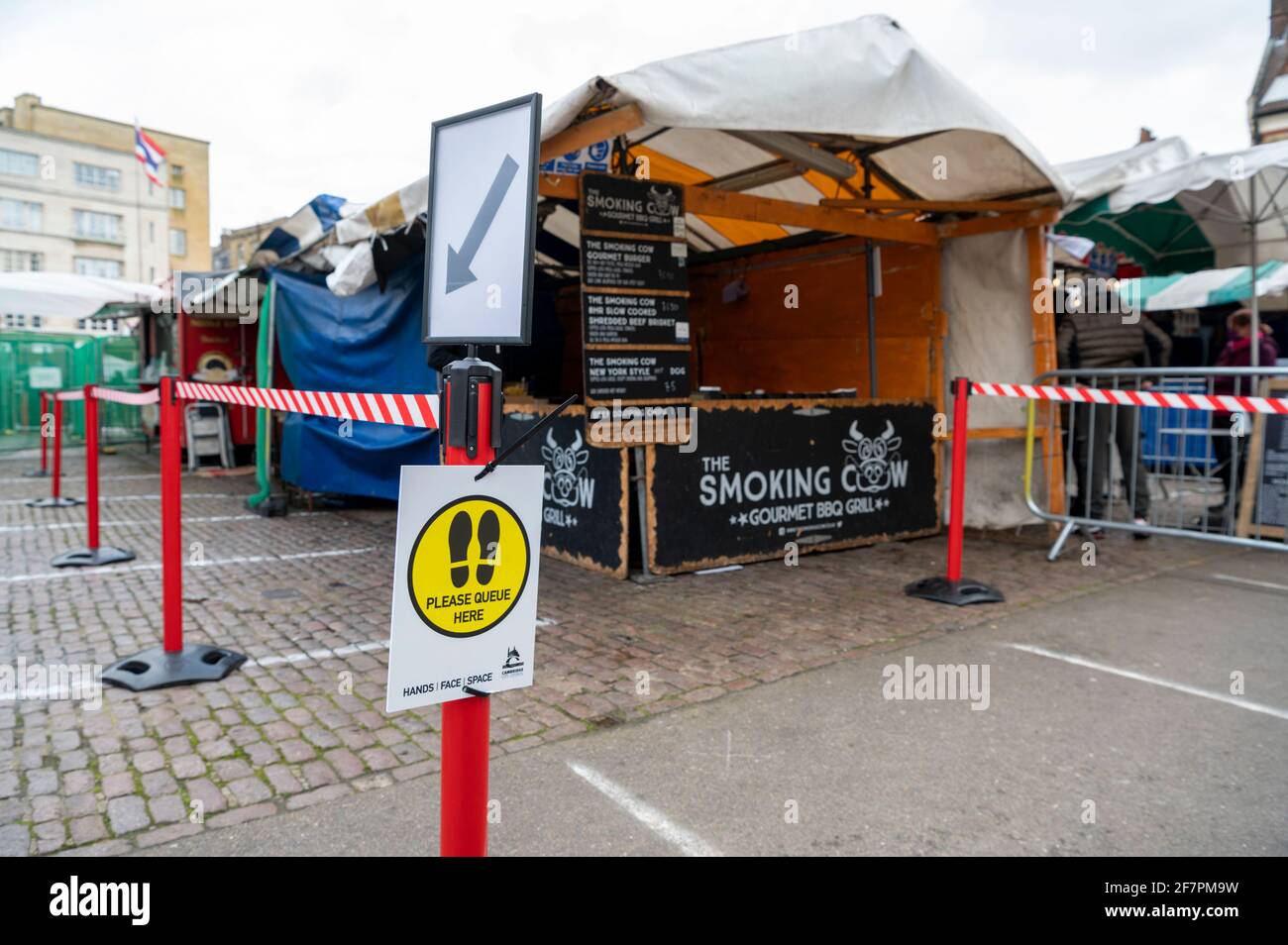 Safety barriers and social distancing measures in response to covid 19 and the coronavirus pandemic in Cambridge market Cambridgeshire UK Stock Photo