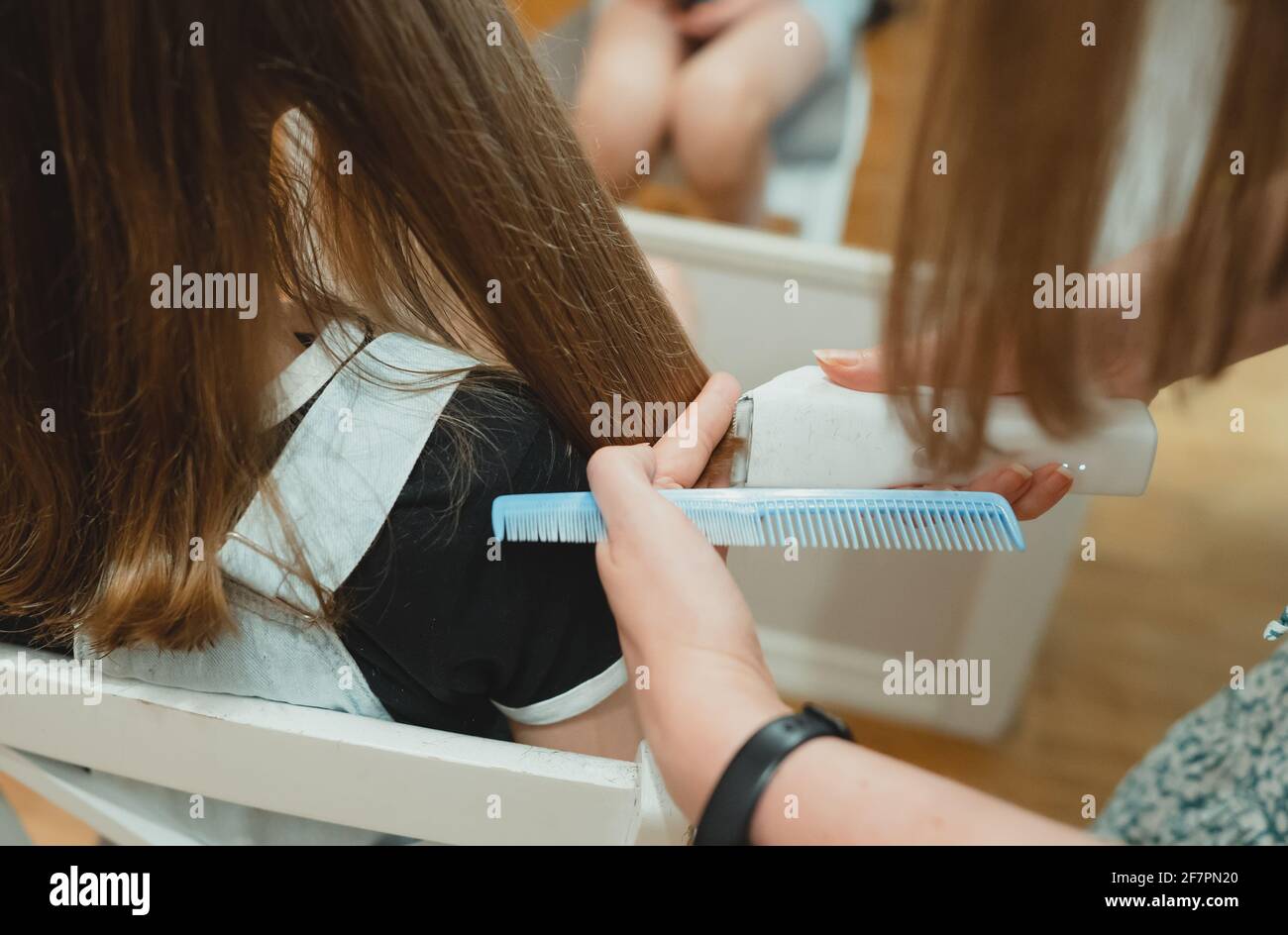 Mom cuts her daughter with a hair clipper at home Stock Photo Alamy