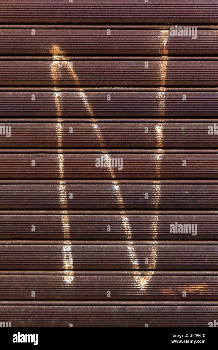 Graffiti of a letter N on rusted metal gate Stock Photo