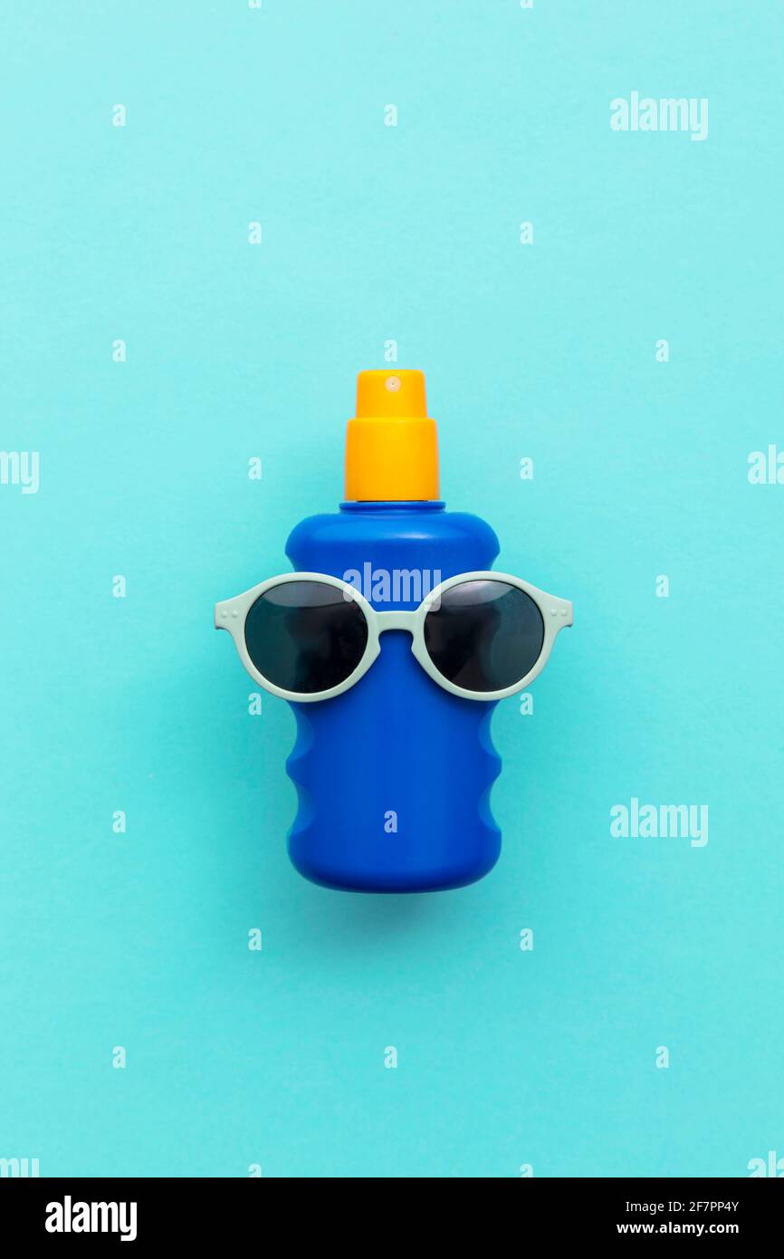 Summer holiday vacation background. Bottle of sun cream with sunglasses Stock Photo