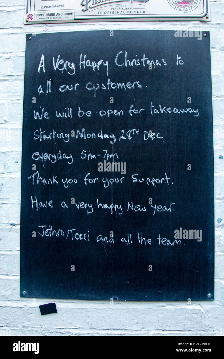 A sign at the Cambridge Blue pub wishing its customers a Happy Christmas with opening times for takeaway only due to Covid-19 safety measures. Stock Photo