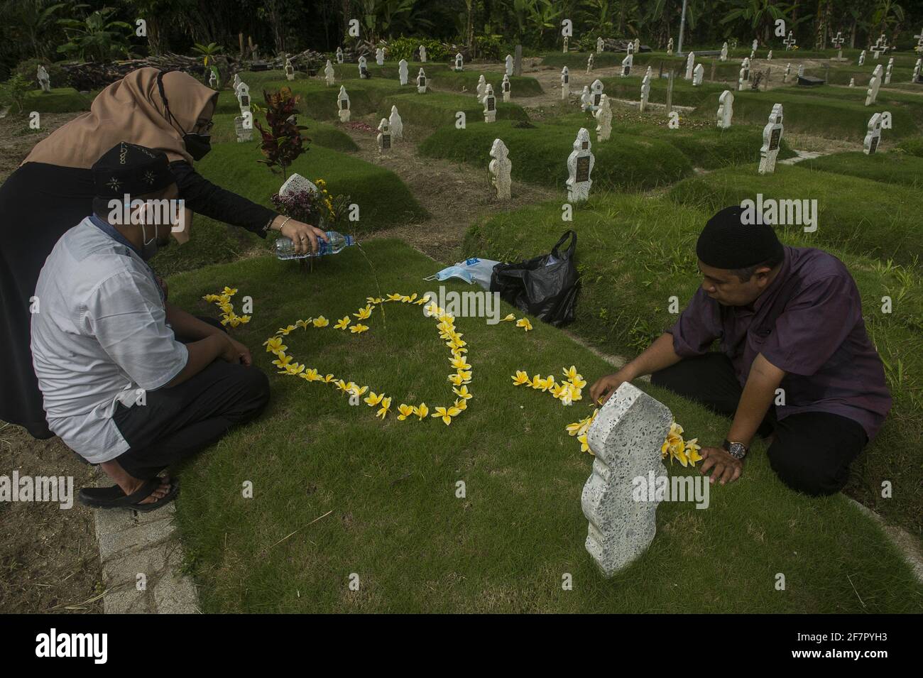 Medan, Indonesia. 09th Apr, 2021. Hanafi's family seen carrying out the tradition of a funeral pilgrimage to welcome the holy month of Ramadan 1442H at specifict cemetery for coronavirus pandemic victims in Medan, Indonesia on April 9, 2021. Hanafi admitted to being sad and traumatized were remembering 9 months ago moment, when his wife died due coronavirus disease-19 in the same time with Eid Al-Fitr 2020. Photo by Sutanta Aditya/ABACAPRESS.COM Credit: Abaca Press/Alamy Live News Stock Photo