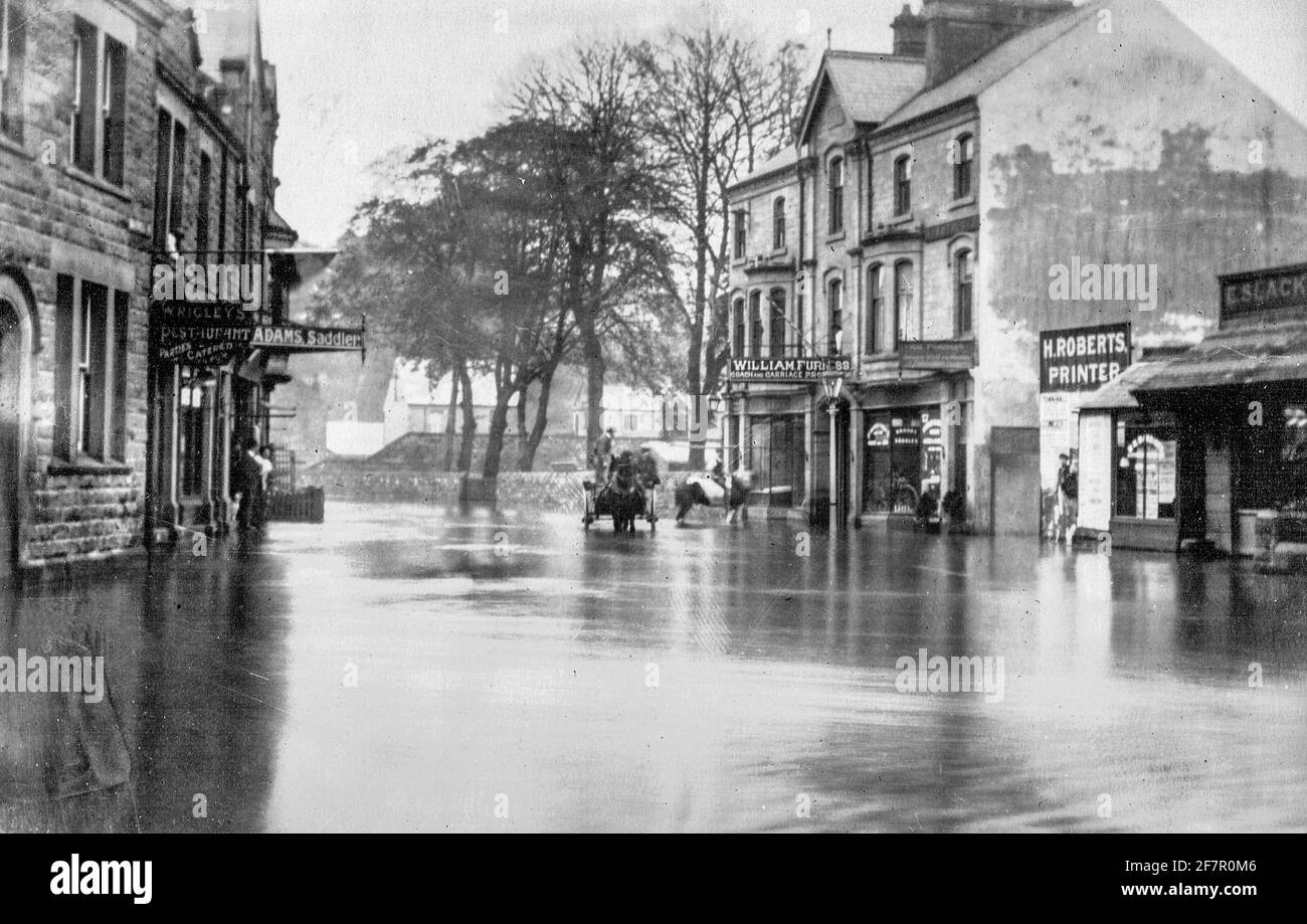 Archival black and white photograph taken in the early twentieth century showing flooding in the centre of Matlock a town in the Derbyshire Peak District England UK. Stock Photo