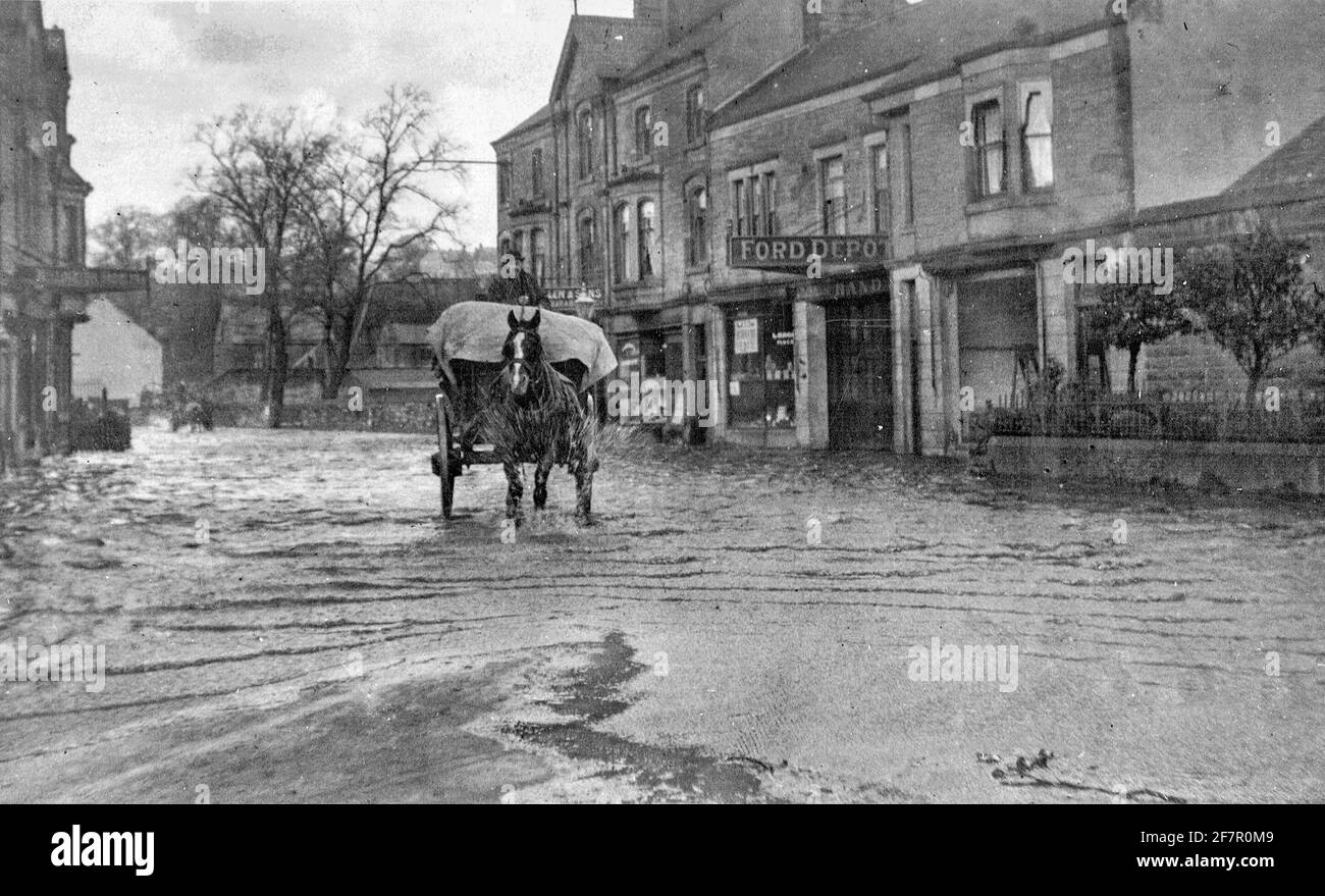 Archival black and white photograph taken in the early twentieth century showing flooding in the centre of Matlock a town in the Derbyshire Peak District England UK. Stock Photo