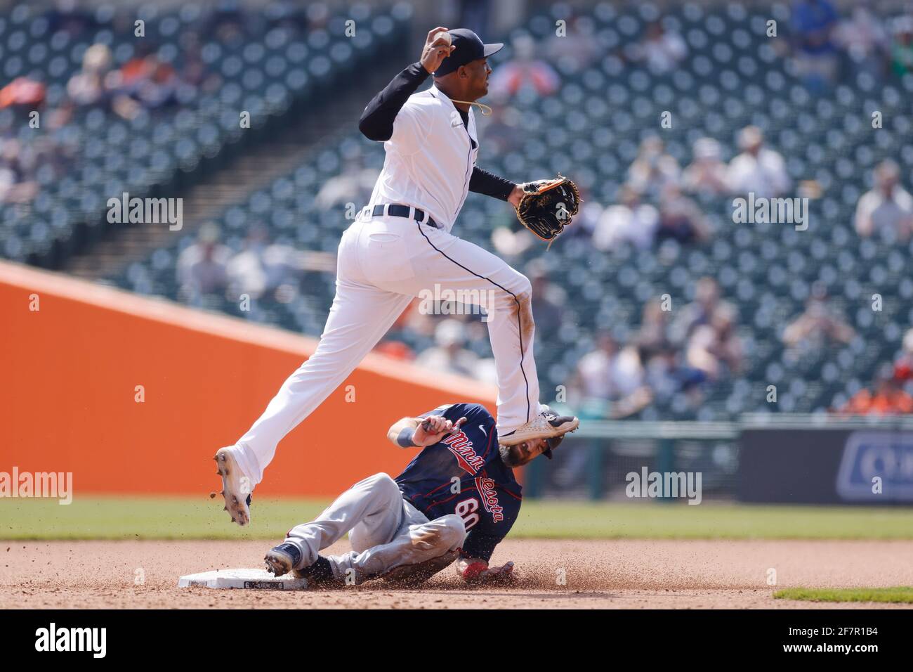 DETROIT, MI - APRIL 6: Jonathan Schoop (7) of the Detroit Tigers jumps over Jake Cave (60) of the Minnesota Twins to turn a double play at Comerica Pa Stock Photo