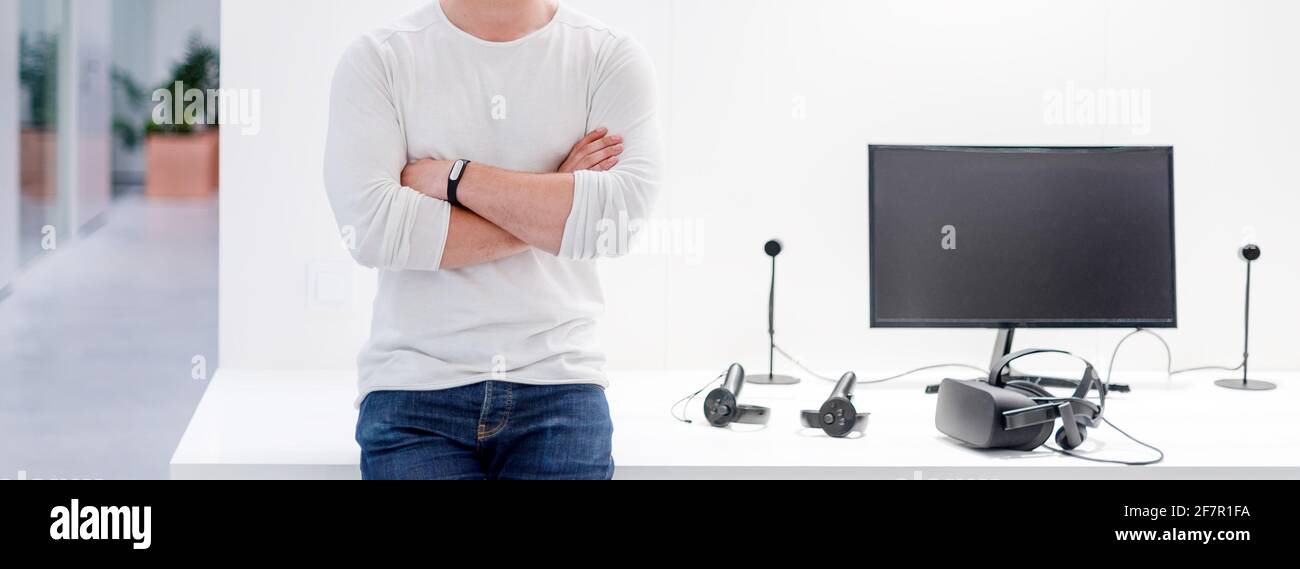 Digital designer standing near computer and virtual reality headset on white table Stock Photo