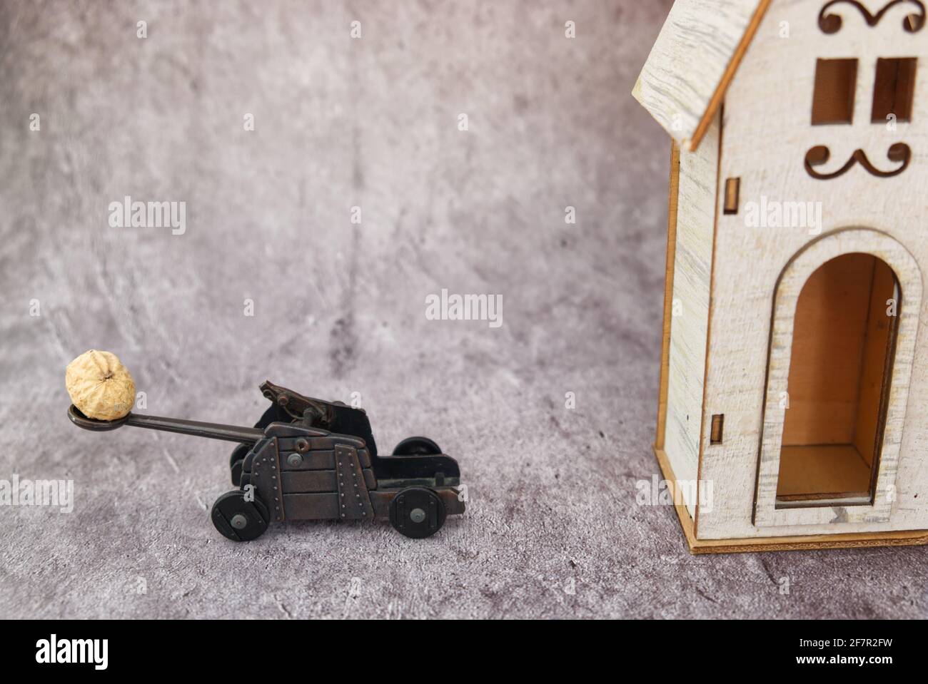 funny diorama of a catapult while pulling a peanut on a wooden house Stock Photo