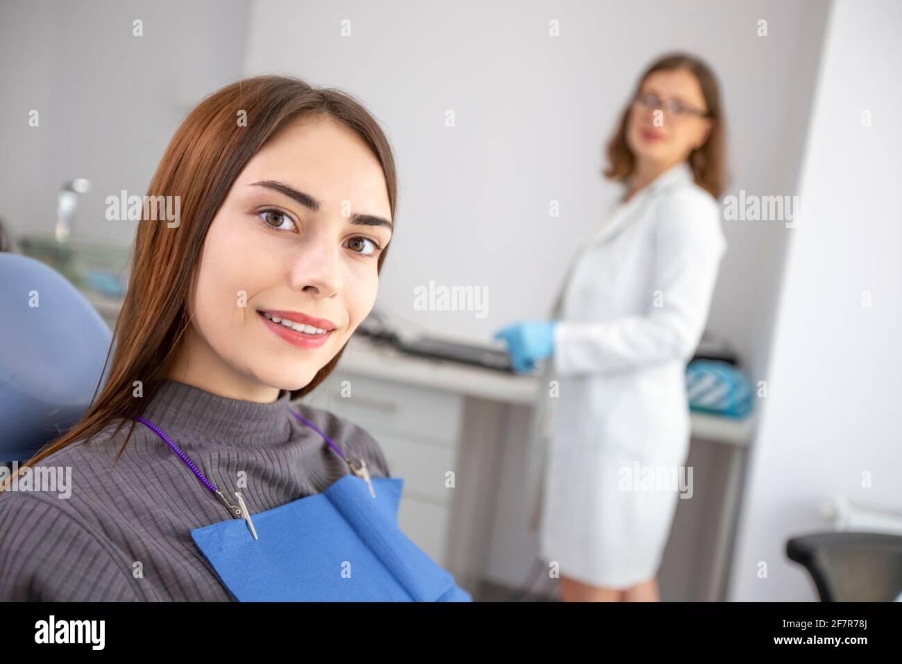 Dentist doctor treats a patient in a clinic. Young woman with white and healthy teeth. Stock Photo