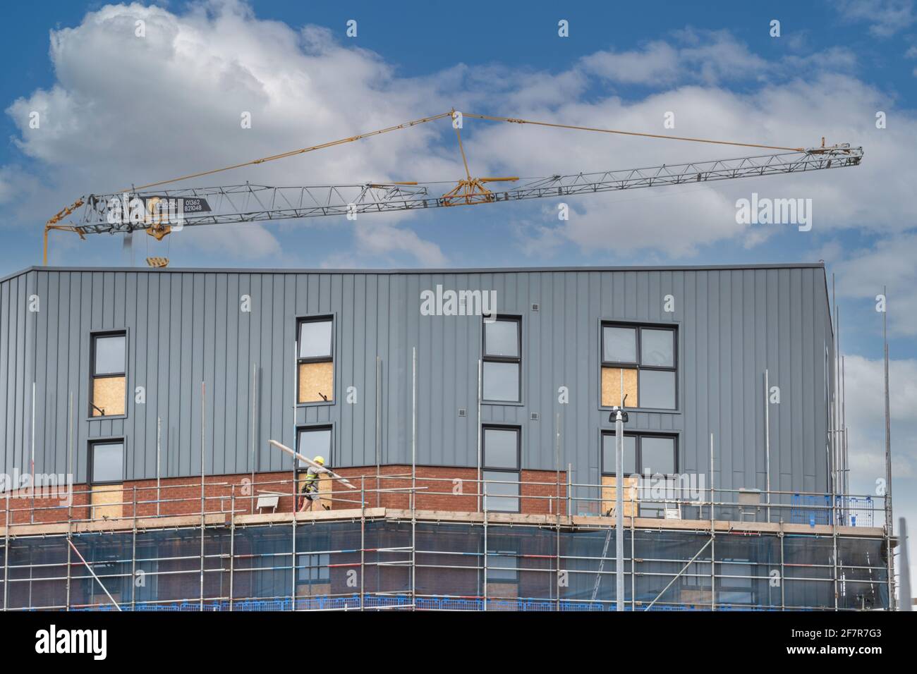A Crane and workers on a construction site or building site Stock Photo