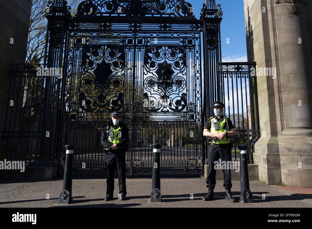 Edinburgh, Scotland, UK. 9 April 2021. Flags fly at half mast in Edinburgh today at the news of the death of Prince Philip the Duke of Edinburgh. Pic; Police stand outside gates to Palace of Holyroodhouse.   Iain Masterton/Alamy Live News Stock Photo