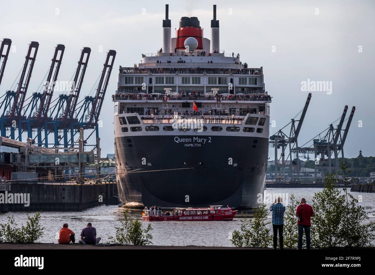 Hamburg Steinwerder. Blick auf das festgemachte Kreuzfahrtschiff Queen Mary 2, eingerahmt von Kränen. Stock Photo