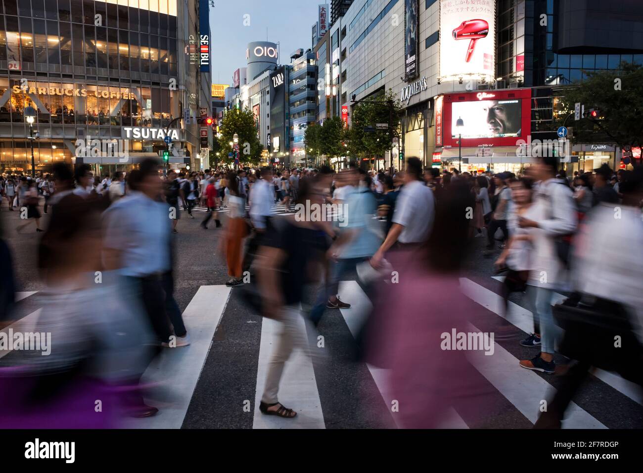 Horizontal view of the pedestrian hustle and bustle in Shibuya Crossing at dusk, Shibuya, Tokyo, Japan Stock Photo