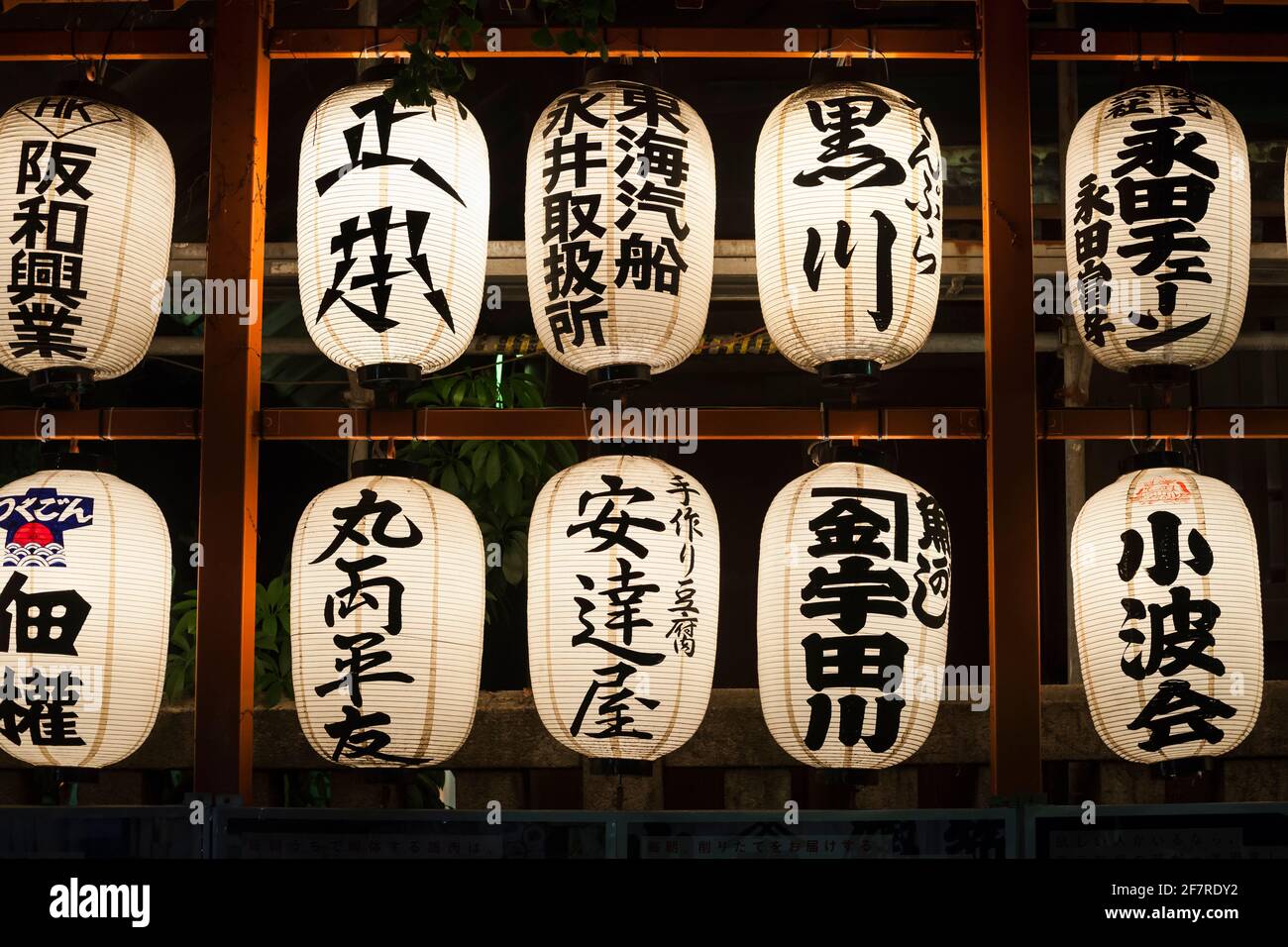 Horizontal view of two rows of illuminated Chinese lanterns in Namiyoke-jinja Shinto shrine at night, Tsukiji, Tokyo, Japan Stock Photo
