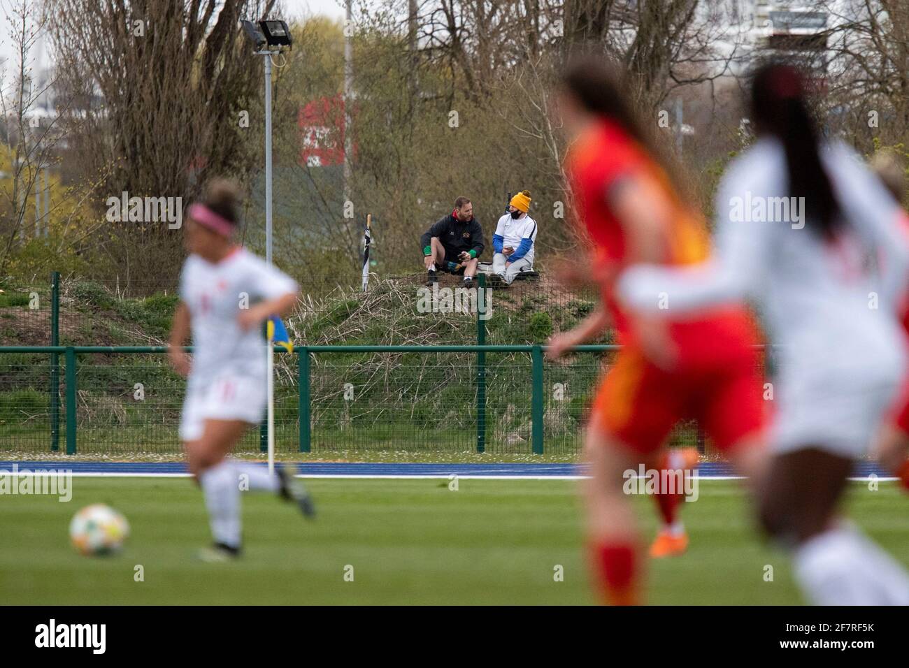 Cardiff, Wales, UK. 9th Apr, 2021. People watch from a mound outside the perimeter fence during the behind- closed-doors friendly international match between Wales Women and Canada Women at Leckwith Stadium in Cardiff. Credit: Mark Hawkins/Alamy Live News Stock Photo