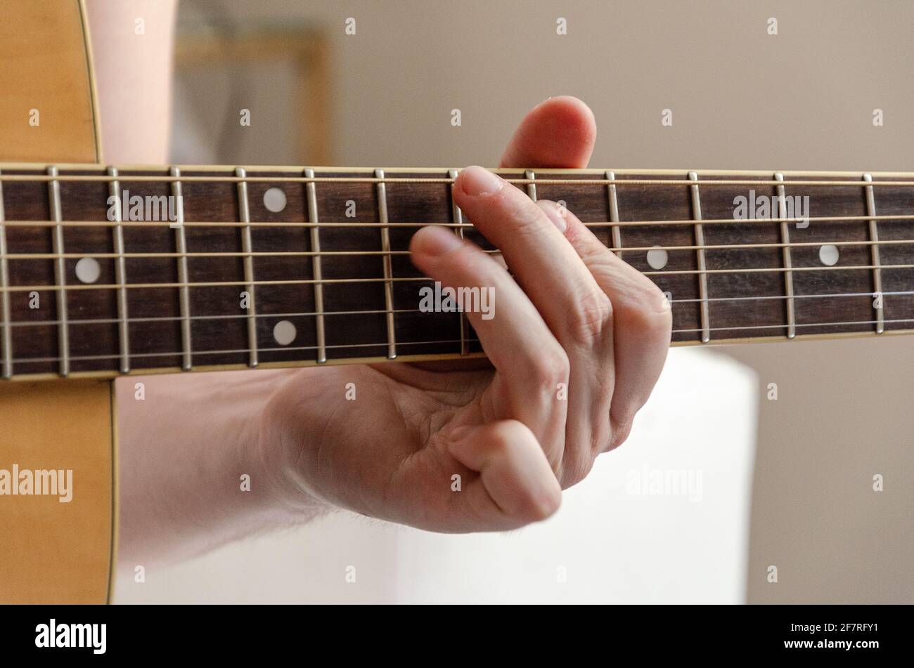 closeup on male fingers playing acoustics arm guitar strings Stock Photo