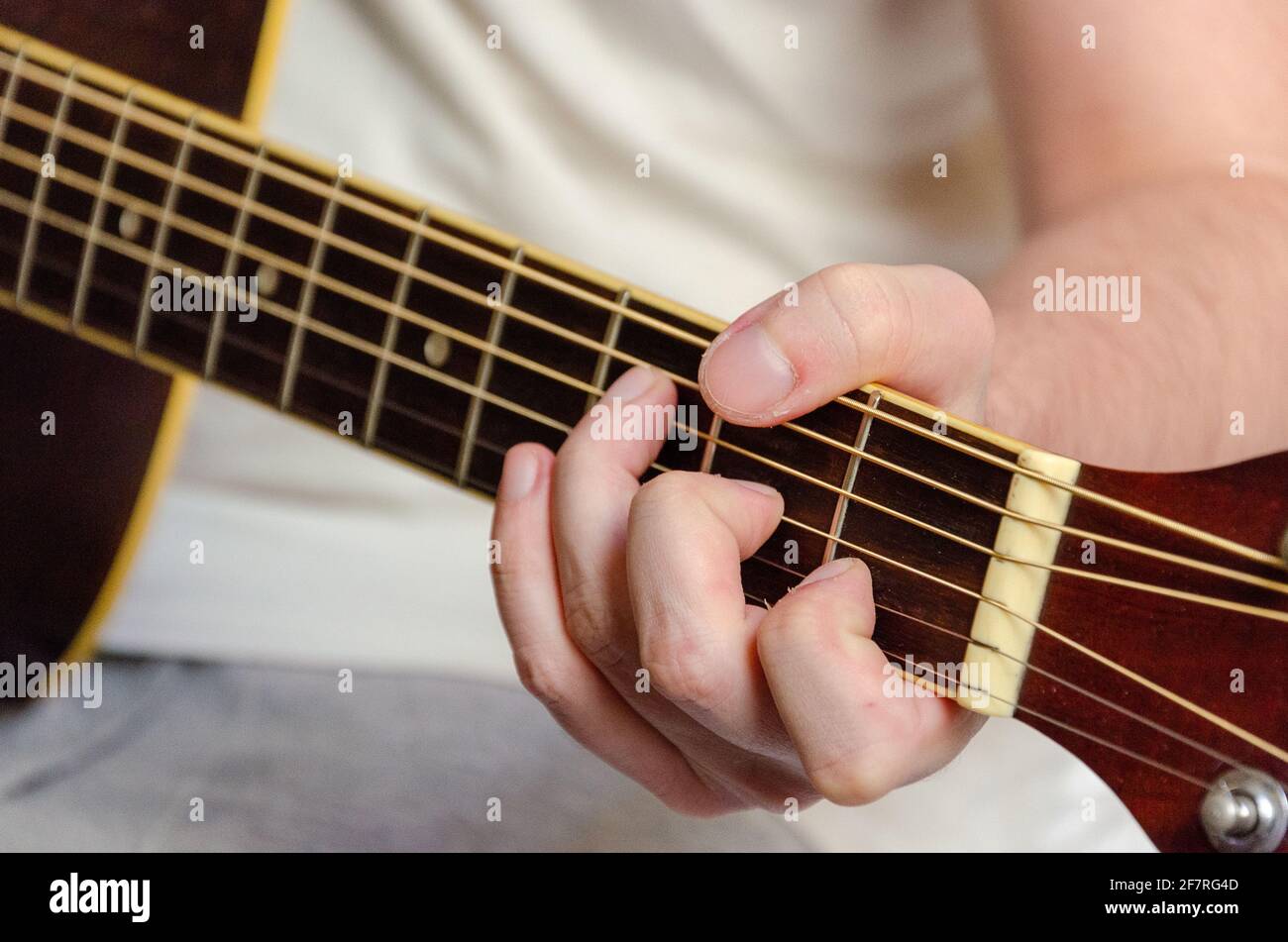 male fingers playing acoustics guitar strings Stock Photo
