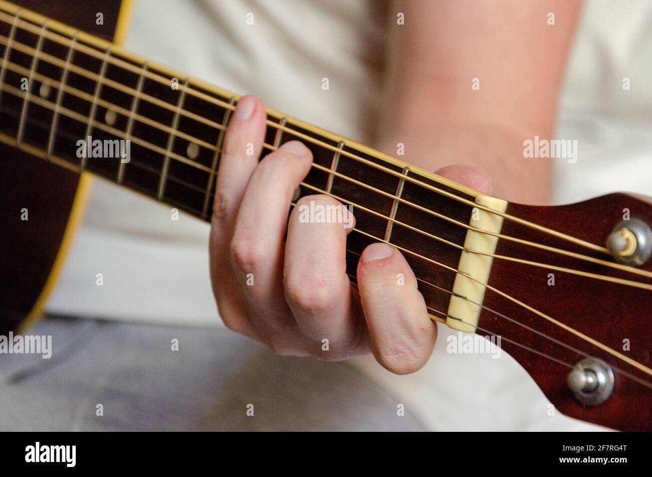 male fingers playing acoustics guitar strings Stock Photo