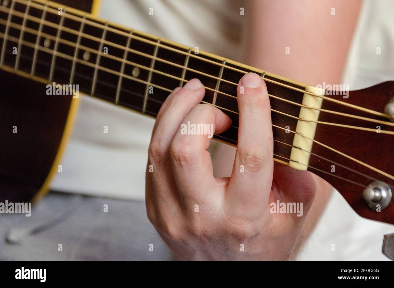 male fingers playing acoustics guitar strings Stock Photo